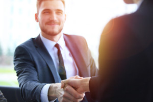 Zwei Personen in Businesskleidung begrüßen sich
